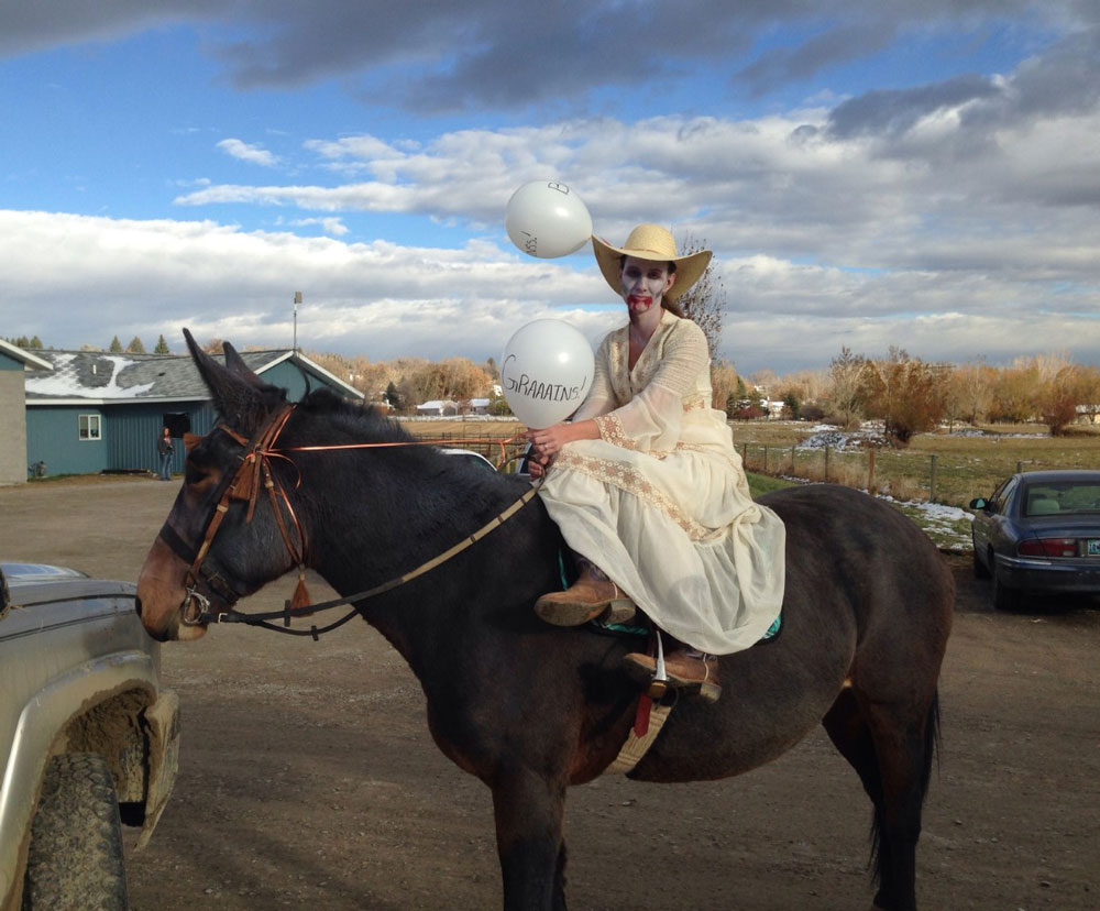 Maggie the mule is dressed up for Halloween as a Zombie and is being ridden in an antique side-saddle.