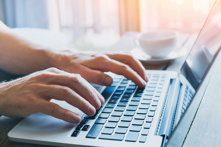 Hands typing on computer keyboard