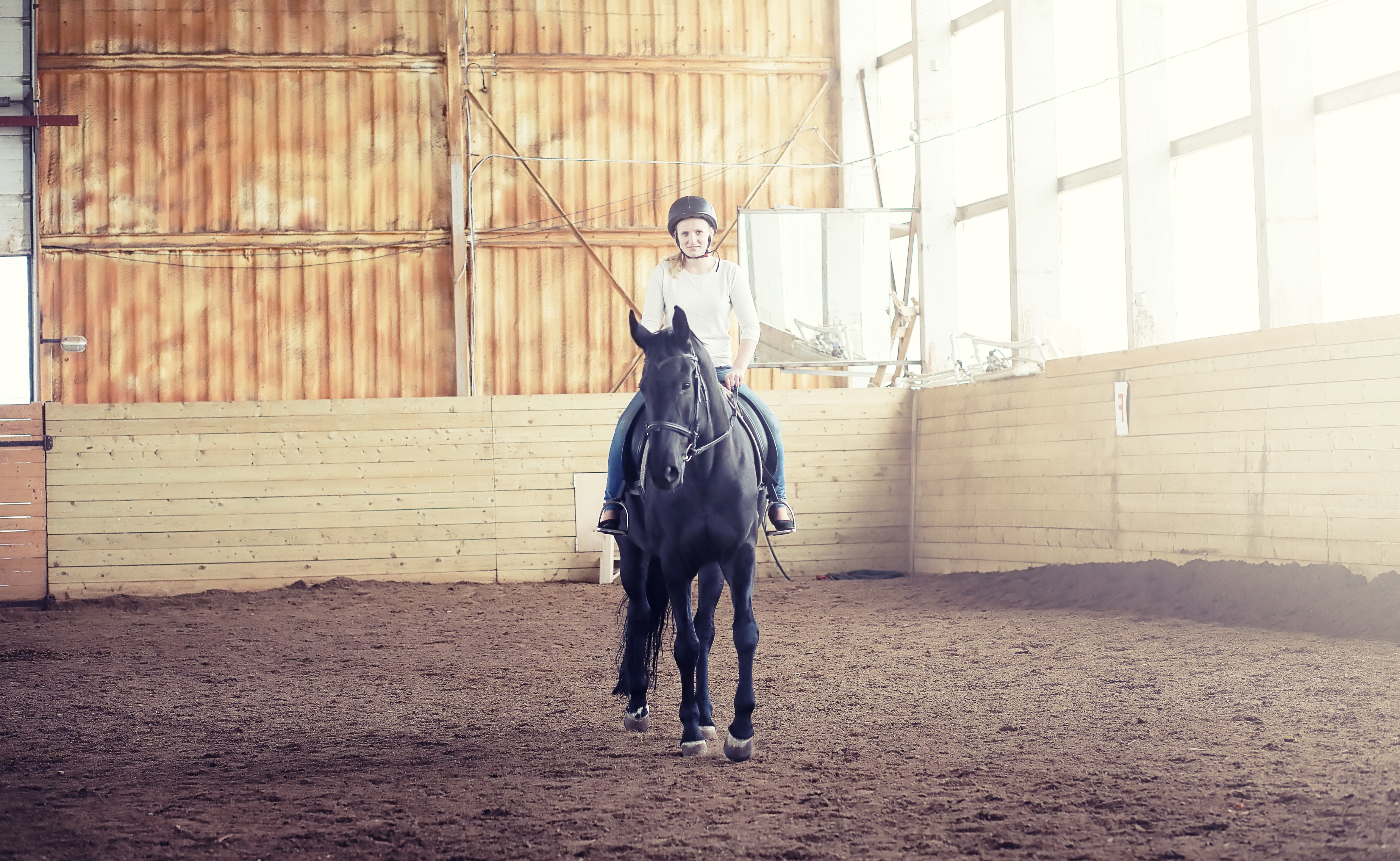 A woman riding in an indoor arena.